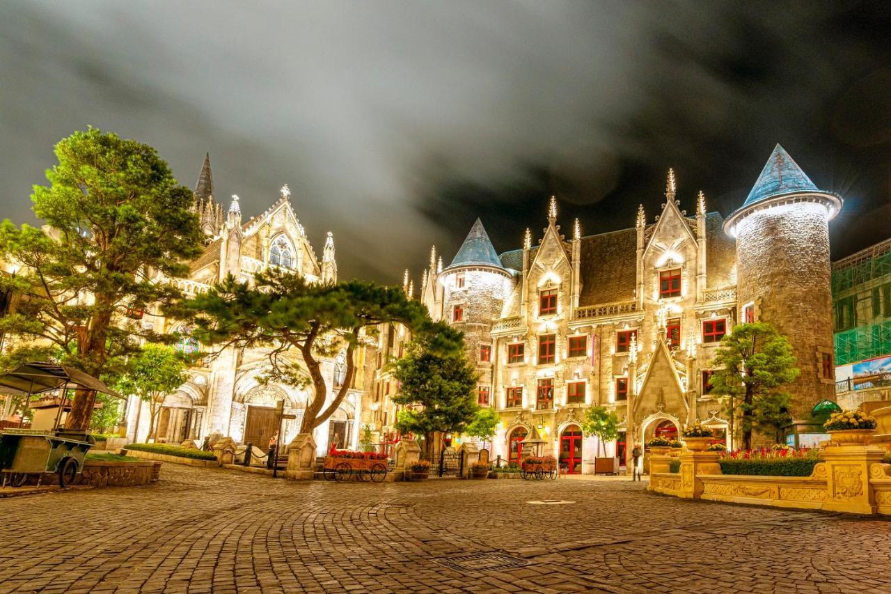 Illuminated facade of the Mercure hotel in the French Village at Ba Na Hills Vietnam at twilight.