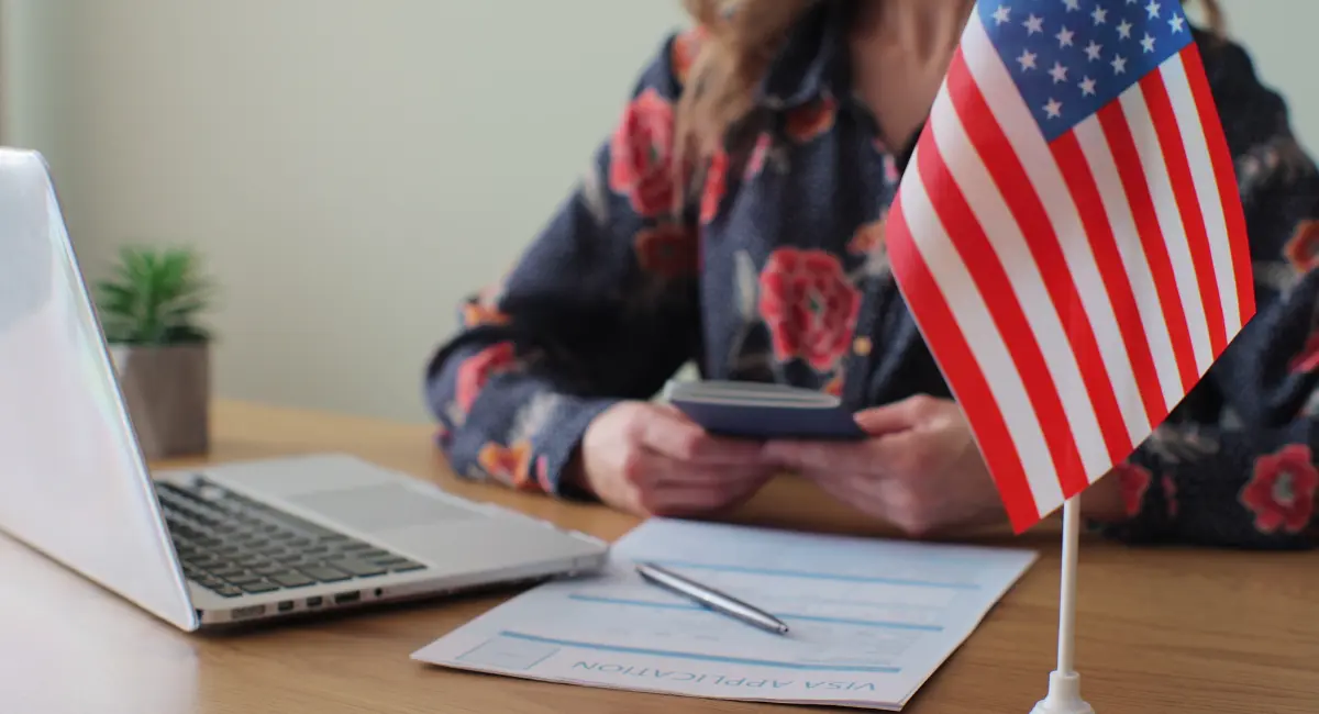 A generic passport and a smartphone showing a digital portrait photo side-by-side on a desk, illustrating Vietnam e-visa document requirements.