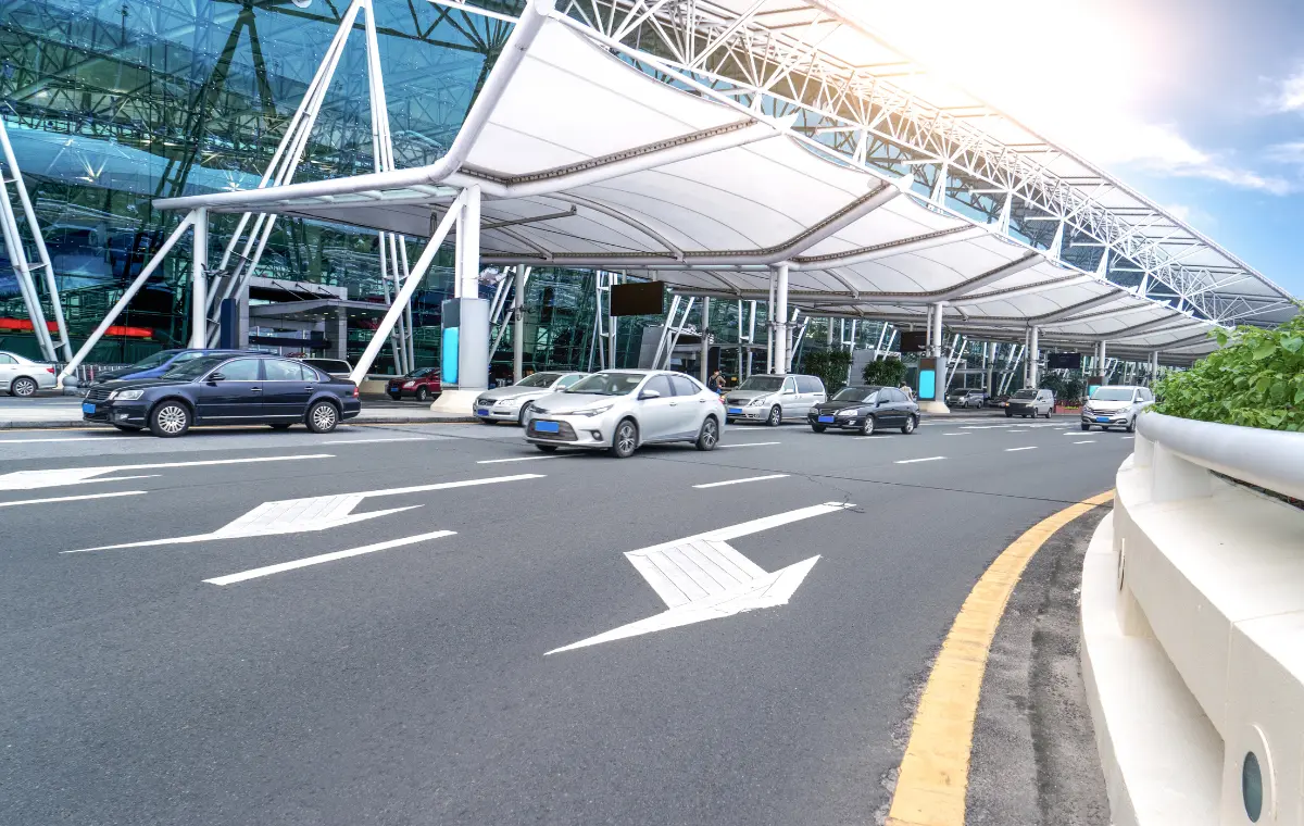 Row of organized, generic taxis waiting at a designated taxi stand outside a Vietnam airport terminal building.