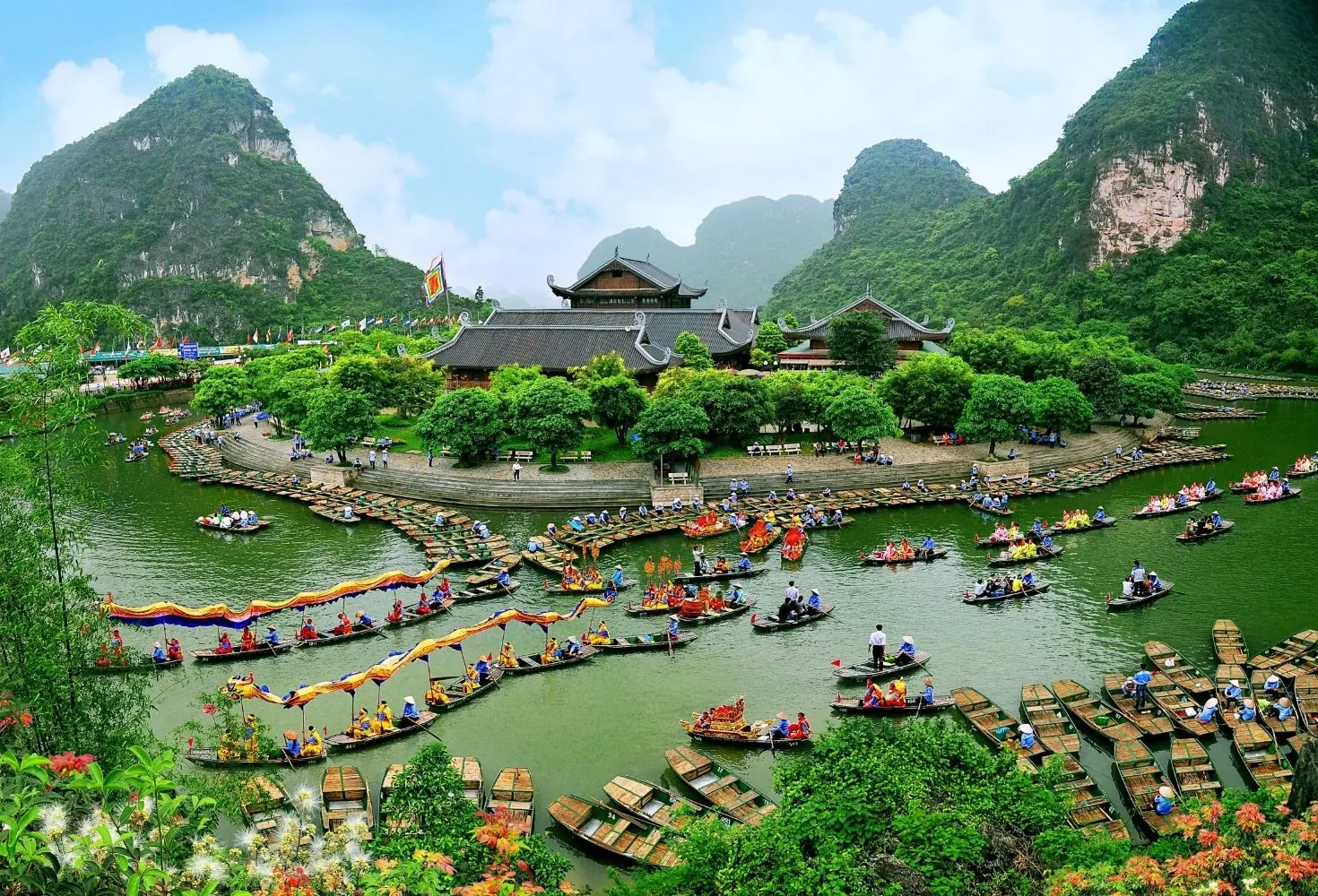 Rowing boat tour amidst towering limestone karsts on the river in Trang An, Ninh Binh Vietnam.