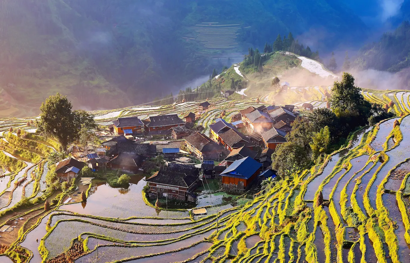 Sweeping view of Sapa town surrounded by misty green mountains under a clear sky in Lao Cai Province, Vietnam.