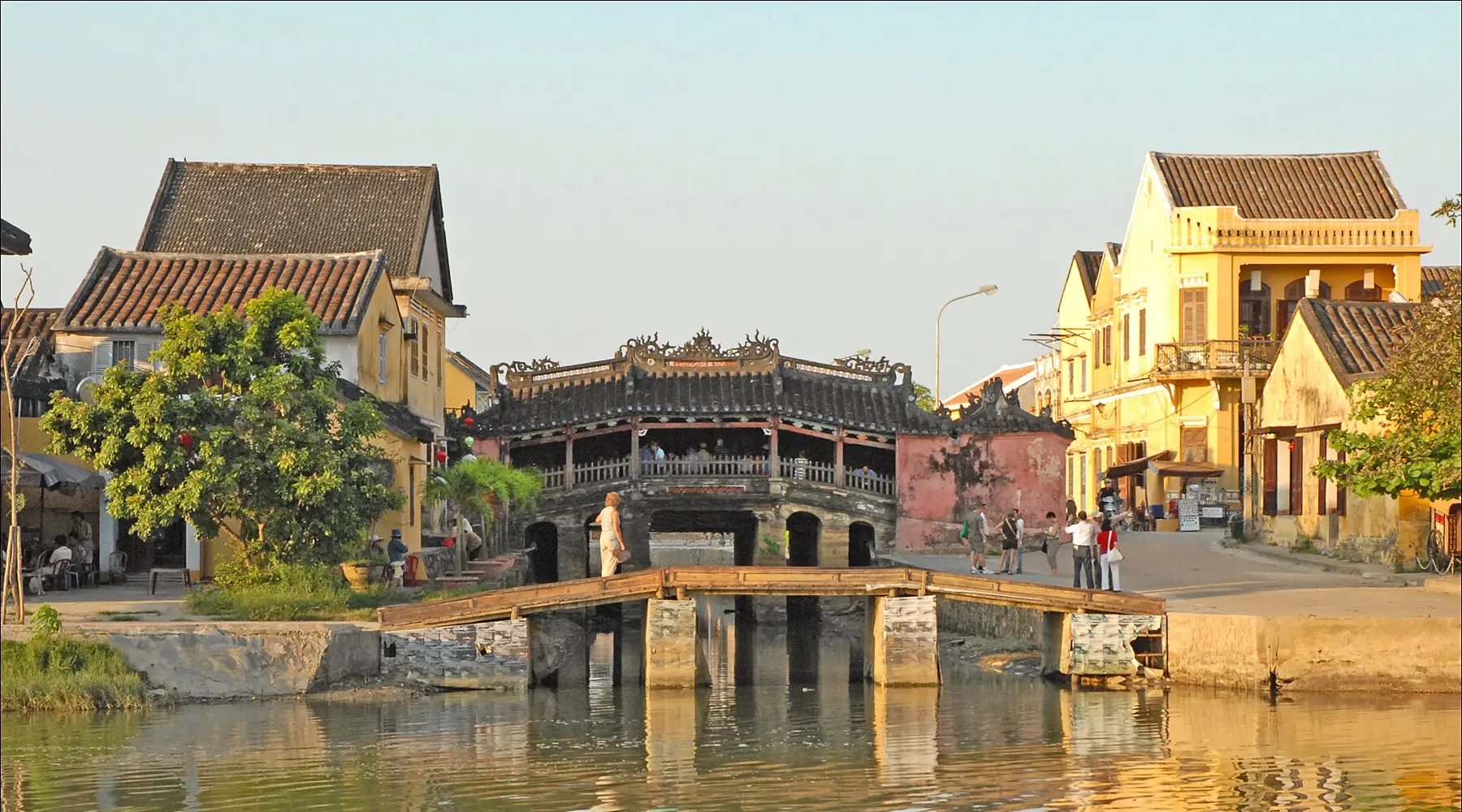 The historic wooden Japanese Covered Bridge landmark in Hoi An Vietnam spans a canal.