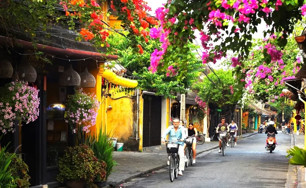 Welcoming street scene with motorbikes and yellow architecture signalling arrival in Hoi An Vietnam.