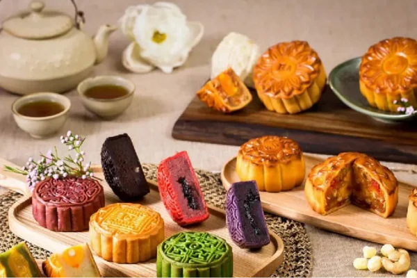 A festive display of colorful mooncakes and tea, arranged for the Mid-Autumn Festival