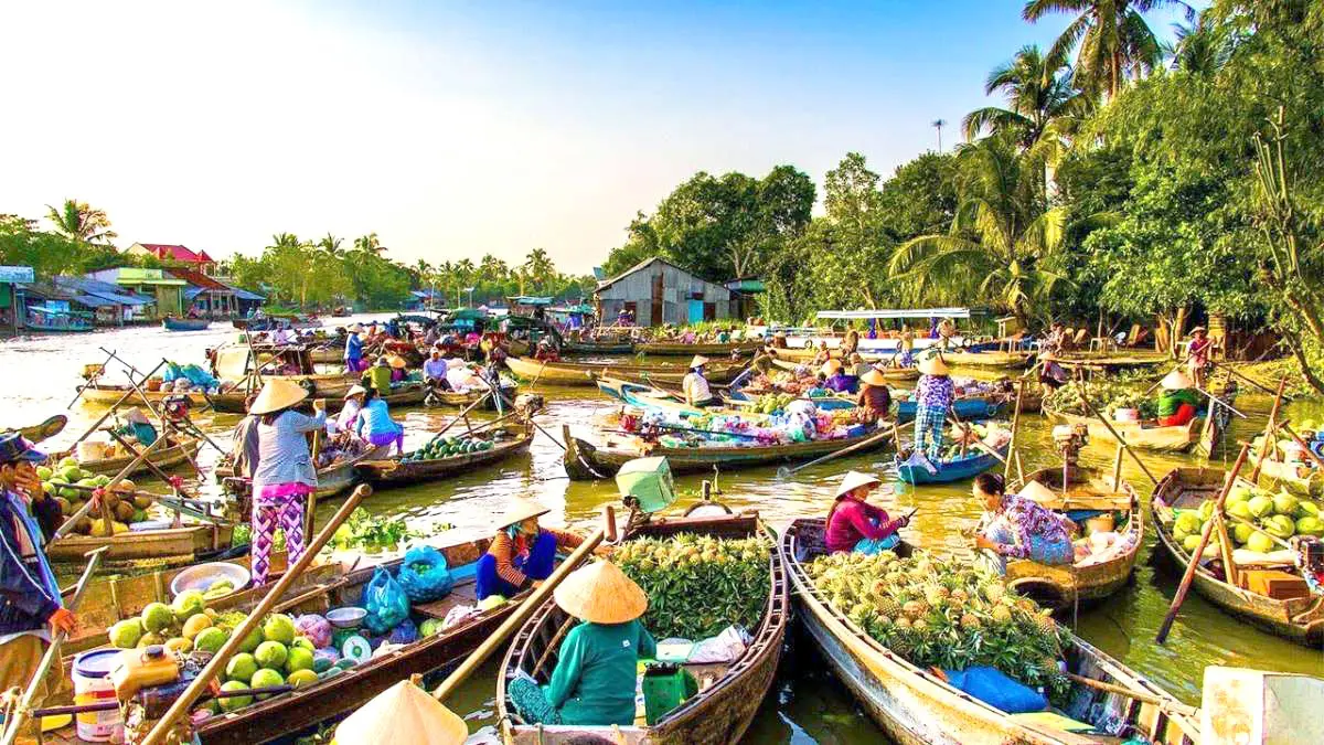 Authentic Cai Rang Floating Market in Can Tho Vietnam with a boat full of colorful fruits.