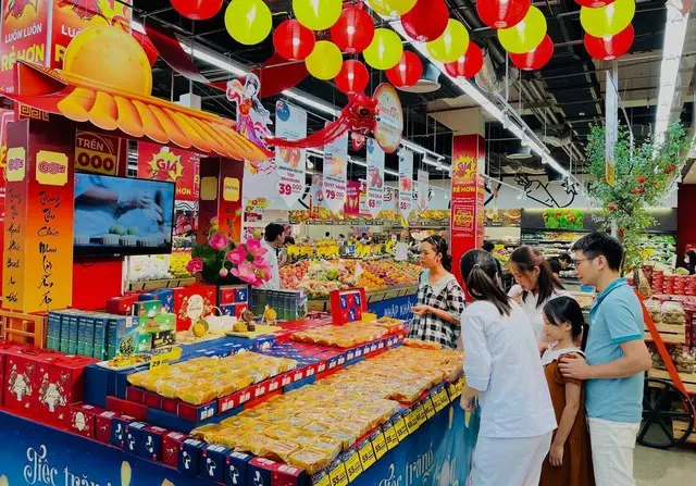 People shopping for mooncakes at a Mid-Autumn Festival decorated stall in a supermarket