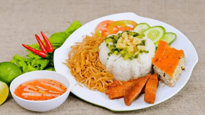 Vietnamese Com Tam (broken rice) with assorted toppings and dipping sauce