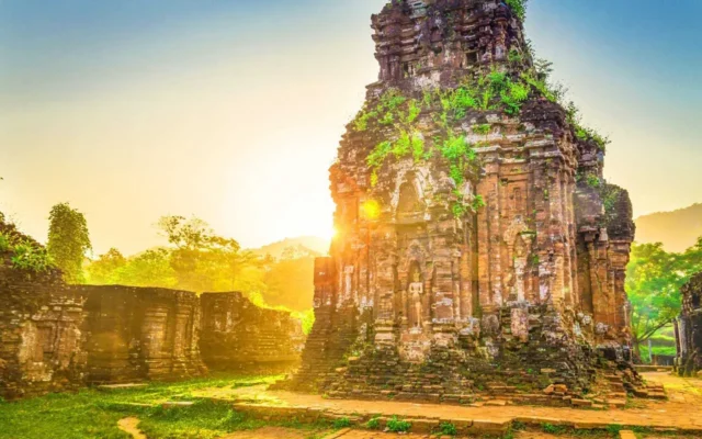 Ancient, plant-covered stone temple ruins bathed in golden sunlight