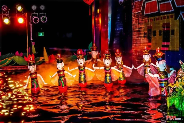 Colorful water puppets perform in a row on a dramatically lit water stage