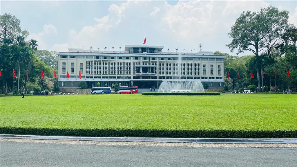 Independence Palace in Ho Chi Minh City, with a large green lawn and fountain in the foreground